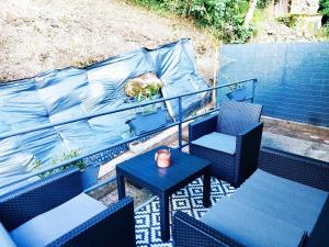 a balcony with blue chairs and a table with a plant at Agréable studio privé avec terrasse in Olliergues