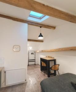 a bedroom with a bed and a table in a room at Agréable studio privé avec terrasse in Olliergues