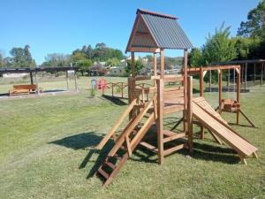 a wooden playground with a gazebo at Cabañas Dolce Far Niente in Tandil