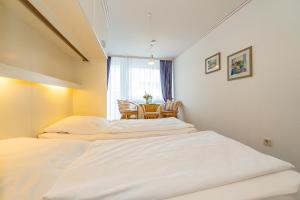 a room with two beds and a table in it at Wiking, App 003 in Westerland