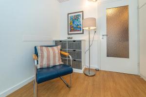 a room with a blue chair and a lamp at Wiking, App 003 in Westerland +11 photos