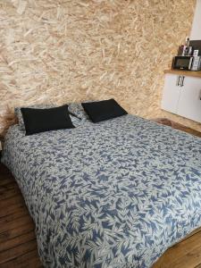 a bed with two pillows on it in a bedroom at Studio in Aurillac