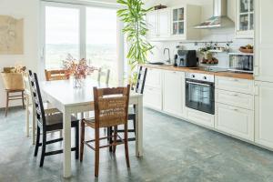 a white kitchen with a table and chairs at Marli Home in Corropoli +24 photos