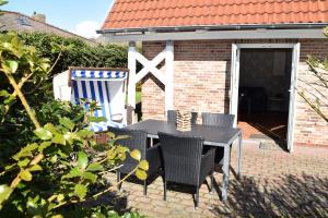 a black table and chairs on a brick patio at Brönswai 5B in Westerland