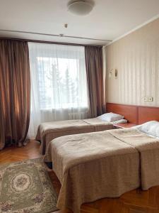 a hotel room with two beds and a window at Hetman Hotel in Lviv