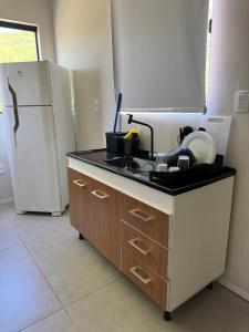 a kitchen with a sink and a refrigerator at Tiny House Campeche - Vista do Lampião in Florianópolis +5 photos