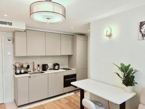 a kitchen with white cabinets and a potted plant at SCI Gomis Invest in Issy-les-Moulineaux