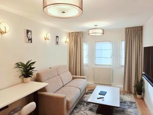 a living room with a couch and a table at SCI Gomis Invest in Issy-les-Moulineaux