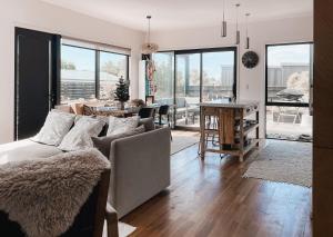 a living room with a couch and a dining room at Kowhai Cabin - Serene Scandi Escape in Hokitika in Hokitika
