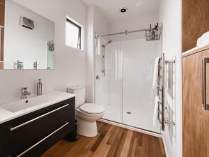 a bathroom with a shower and a toilet and a sink at Kowhai Cabin - Serene Scandi Escape in Hokitika in Hokitika +26 photos