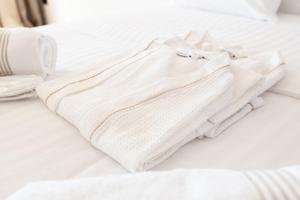 a white shirt sitting on top of a bed at Megara Hotel in Megara