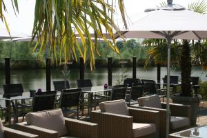 a restaurant with tables and chairs and a river at Hotel Buenos in Geldrop