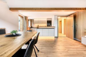 a kitchen and dining room with a wooden table and chairs at Ferienwohnung Gipfelstube in Brand