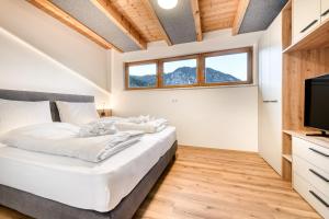 a bedroom with a bed and a flat screen tv at Ferienwohnung Gipfelstube in Brand