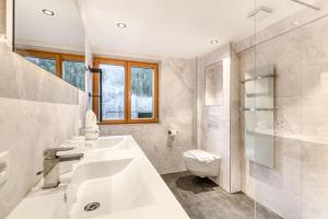 a white bathroom with a sink and a toilet at Ferienwohnung Gipfelstube in Brand +22 photos