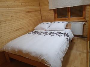 a bed with white sheets and pillows in a room at Leśna Przystań in Sidzina +24 photos