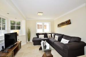 a living room with a couch and a tv at Ferienhaus Litj Stig in Westerland