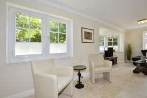 a living room with white furniture and windows at Ferienhaus Litj Stig in Westerland