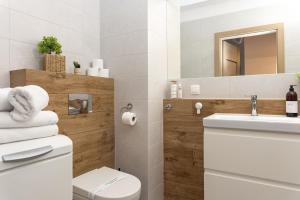 a bathroom with a toilet and a sink and a mirror at Luxus Apartament Róża in Gdynia +32 photos