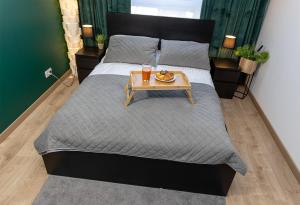 a bedroom with a bed with a table on it at Luxus Apartament Róża in Gdynia