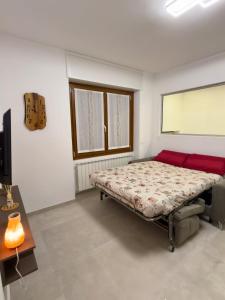 a bedroom with a bed and a red couch at Casa Alpea in Villadossola