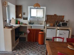eine kleine Küche mit Spüle und Tisch in der Unterkunft Le Micolo in Mailly-le-Château