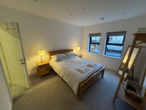 a bedroom with a bed and two windows and a door at 10 Argyle Court in Whitby