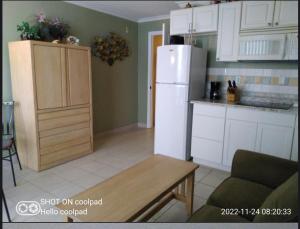 a kitchen with a white refrigerator and a table at Harbour Beach Resort in Daytona Beach