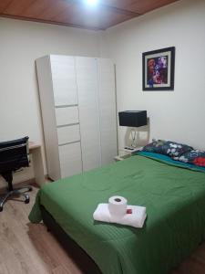 a bedroom with a green bed with a desk and a chair at Habitación familiar Maoservi in Soacha