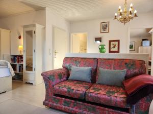 a living room with a red couch and a chandelier at Schwarzwald-Ferienwohnungen Begert in Baiersbronn