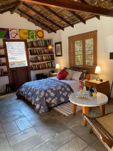 a bedroom with a bed and a table at Villa Violeta in Petrópolis +56 photos