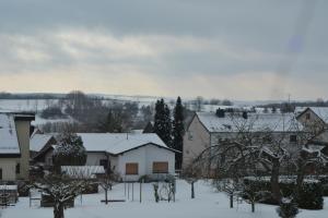 a village with snow covered roofs and buildings at Wolkenfrei am Sonnenhang - Moderne Wohlfühl-Oase mit sonniger Süd-Terrasse in Lebach