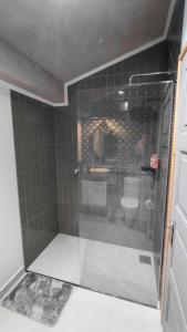 a bathroom with a glass shower with a sink at Casas do Pargo - Casa B Palheiro in Ponta do Pargo
