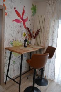 a table with a bottle of wine and two chairs at Wolkenfrei am Sonnenhang - Moderne Wohlfühl-Oase mit sonniger Süd-Terrasse in Lebach
