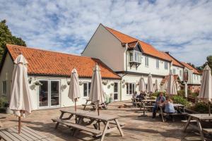 un grupo de mesas y sombrillas frente a un edificio en Wayford Bridge Inn Hotel, en Stalham