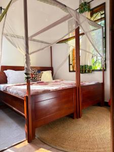 a bedroom with a wooden bed with a canopy at Sophie Homestay in Moshi