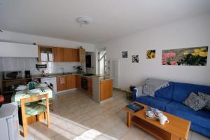 a living room with a blue couch and a kitchen at Casa Palmira in Drena