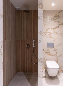 a bathroom with a toilet and a shower stall at Pelago White in Skala Potamias