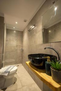 a bathroom with a black sink and a toilet at Villa Papazoglou in Neos Pirgos