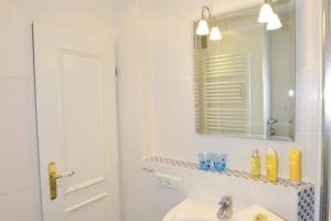a white bathroom with a sink and a mirror at Birgit, App 4 "Sterntaucher" in Westerland