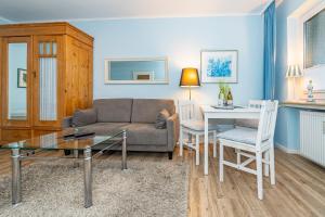 a living room with a couch and a table and chairs at Birgit, App 4 "Sterntaucher" in Westerland +13 photos