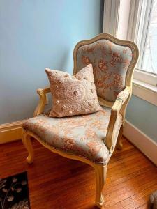 a chair with a pillow in a room with a window at Bluebell Room in Oswego