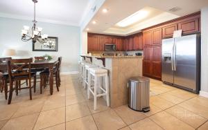 a kitchen with wooden cabinets and a stainless steel refrigerator at Phoenix Gulf Shores 1602 in Gulf Shores