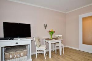 a living room with a table and a tv at Eydum, App 45 in Westerland