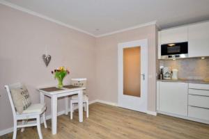 a kitchen and dining room with a table and chairs at Eydum, App 45 in Westerland