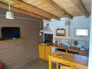 a room with a wooden desk and a television at cabañas UMA RAYMI in Juella