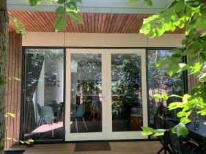 a conservatory with sliding glass doors with a table and chairs at Litehomeatseagoedereede in Goedereede