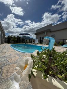 a swimming pool with a white flower in a planter at Casa de descanso, completa, para ate 05 pessoas in Pântano Grande