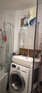 a kitchen with a washing machine and a refrigerator at Studio meublé vue tour Eiffel et tout Paris in Saint-Maurice