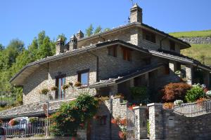 a stone house with flowers on the front of it at B&B Les Fleurs in Gignod